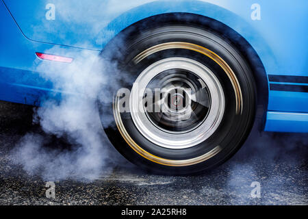 Coche a la deriva. Drag Racing Car quema el caucho de los neumáticos antes del inicio Foto de stock