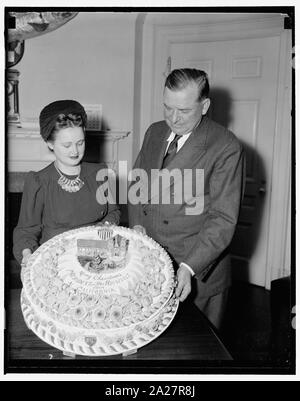 Presidente obtiene Xmas pastel de frutas. Washington, ., el 19 de  diciembre. Brig. Gen. Edwin Watson, Secretario Presidencial, aceptando por  el Presidente Roosevelt, un pastel de frutas de la señorita Mildred Cook,