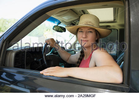 Mujer vistiendo sombrero mirando a través de la ventana de la carretilla