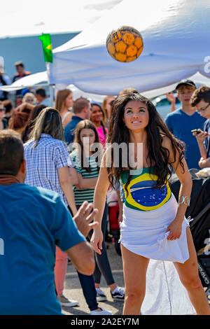 Detroit, Michigan - una joven mujer es la cabeza de un balón de fútbol durante el Festival anual de días en la calle de Brasil. Foto de stock