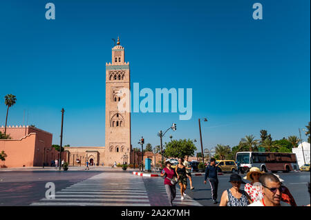 Marrakech, Marruecos - 22 de septiembre de 2019 : los turistas cruzar la calle en frente de la mezquita de Koutoubia Foto de stock