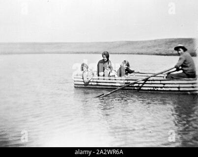 Negativo - Prooinga, Victoria, 1935, un hombre, una mujer y tres niños en un barco hecho de hierro corrugado Foto de stock