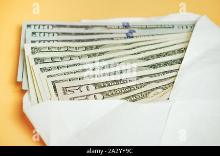 Cerrar hermosa dólares en sobre un fondo amarillo. Dólares americanos, dinero en efectivo. Billetes de cien dólares . Foto de stock