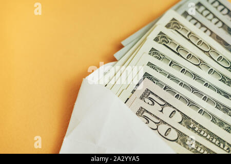 Cerrar hermosa dólares en sobre un fondo amarillo. Dólares americanos, dinero en efectivo. Billetes de cien dólares . Foto de stock