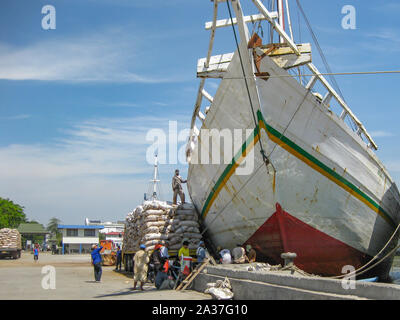 Yakarta, Indonesia - Julio 13, 2009: los trabajadores no cualificados tienen un descanso de sacos de carga de un camión a un buque de transporte de madera Foto de stock