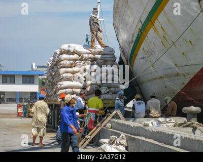 Yakarta, Indonesia - Julio 13, 2009: los trabajadores no cualificados tienen un descanso de sacos de carga de un camión a un buque de transporte de madera Foto de stock