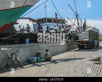 Yakarta, Indonesia - Julio 13, 2009: los trabajadores no calificados cargando sacos de un camión a un buque de transporte de madera Foto de stock