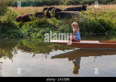 Una bonita niña sentada en la proa de una batea en el río Cherwell en Oxford, Oxfordshire