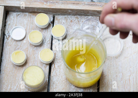 4. Schritt Lippen-und-Pfoten-Salbe selbermachen, selber machen, selber rühren: Fichtenharz, Olivenöl, Bienenwachs und Honig werden gerührt kalt. Lippe Foto de stock