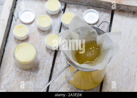 3. Schritt Lippen-und-Pfoten-Salbe selbermachen, selber machen, selber rühren: im Harz Bienenwachs Olivenöl verflüssigtes und werden durch ein feines Foto de stock