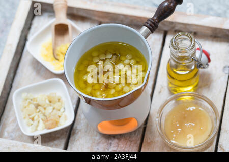 2. Schritt Lippen-und-Pfoten-Salbe selbermachen, selber machen, selber rühren: Fichtenharz, und Olivenöl Bienenwachs werden auf einem Stövchen mit Tee Foto de stock
