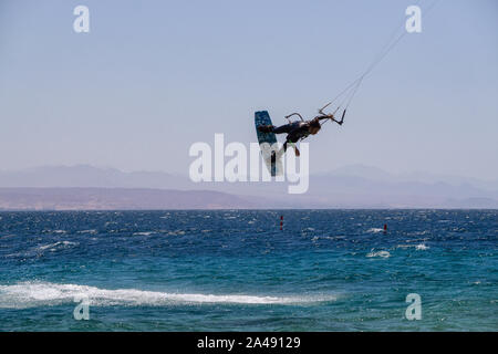 Eilat, Israel - 12 de abril de 2019: el hombre es aventurero disfrutar de deportes acuáticos, Kitesurf, en el Mar Rojo durante un día soleado. Foto de stock