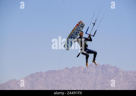 Eilat, Israel - 12 de abril de 2019: el hombre es aventurero disfrutar de deportes acuáticos, Kitesurf, en el Mar Rojo durante un día soleado. Foto de stock
