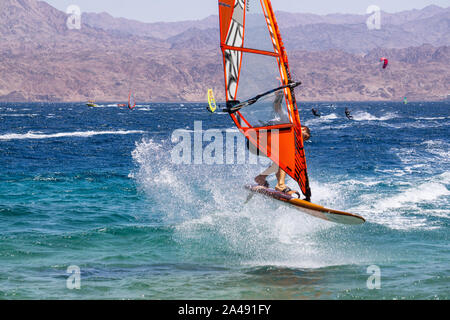 Eilat, Israel - 12 de abril de 2019: el hombre es aventurero disfrutar de deportes acuáticos, windsurf, en el Mar Rojo durante un día soleado. Foto de stock