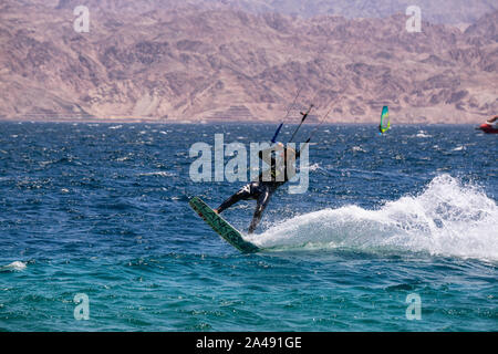 Eilat, Israel - 12 de abril de 2019: Los Aventureros están disfrutando de los deportes acuáticos, Kitesurf, en el Mar Rojo durante un día soleado. Foto de stock