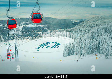 Admirables árboles cubiertos de nieve y esquí en invierno, con coloridos rápido cable cars. Estación de esquí y lago congelado en Poiana Brasov, famosa estación de esquí, Transy Foto de stock