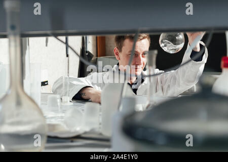 Young Scientist realiza experimentos químicos en el laboratorio. Foto de stock
