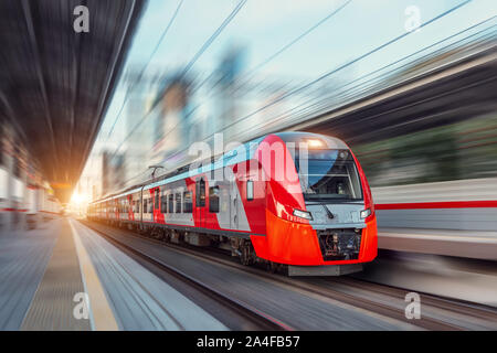 Unidades de tren eléctrico del pasajero a alta velocidad entre paisaje urbano Foto de stock
