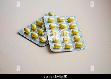 Se cerró la tableta amarilla en el envase del blíster. Cápsulas y pastillas envasadas en ampollas. Concepto farmacéutico y sanitario.