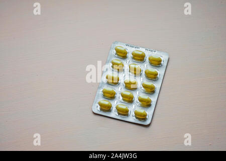 Se cerró la tableta amarilla en el envase del blíster. Cápsulas y pastillas envasadas en ampollas. Concepto farmacéutico y sanitario.