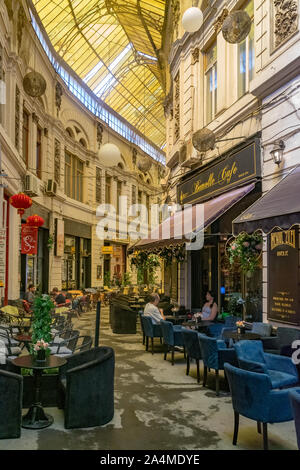 Bucarest, Rumania - 27 julio, 2019: Restaurantes en el Macca Villacrosse Passage - en forma de horquilla, amarillo cubierto de cristal en el centro de la calle porticada Bucha Foto de stock