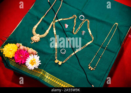 Mangalsutra, bodas y otros collares aparece en una tabla durante la ceremonia de matrimonio hindú en Maharashtra, India Foto de stock