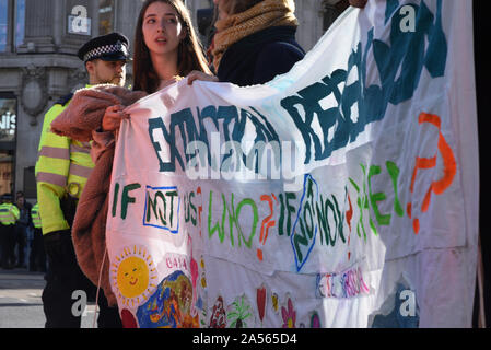 Londres, Reino Unido. 18 Oct, 2019. Los jóvenes manifestantes mantenga una extinción rebelión signo como cambio climático activits ocupan londinense de Oxford Circus. Crédito: Kevin Shalvey/Alamy Live News