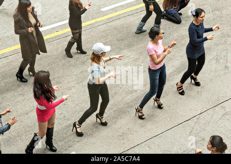 Los trabajadores domésticos filipinos se reúnen en su día libre y mantenga una línea improvisada danza en el Distrito Central de Hong Kong. Aproximadamente 130.000 empleados domésticos filipinos trabajan en Hong Kong y tienen todos los domingos. Foto de stock