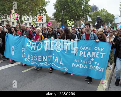 Vista de extinción rebelión manifestantes marchando hacia abajo Whitehall en Londres durante una marcha el viernes 18 de octubre de 2019