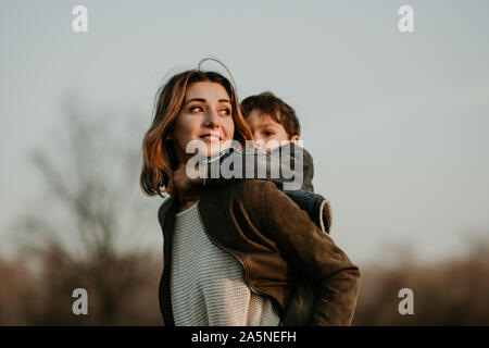 Retrato de feliz madre e hijo pasar tiempo juntos en otoño a pie