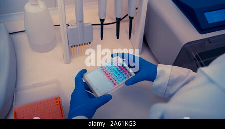 El científico trabaja en moderno laboratorio con diferentes muestras de color Foto de stock