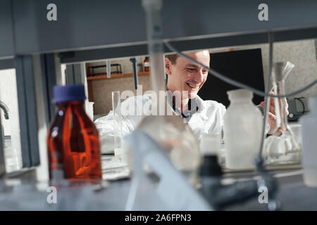 Young Scientist realiza experimentos químicos con líquidos en el laboratorio de ciencias Foto de stock