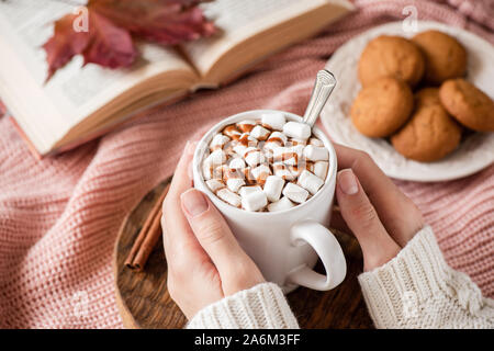 Chocolate caliente con malvaviscos en manos femeninas. Bebida caliente comodidad acogedora comida para el otoño y la temporada de vacaciones de invierno