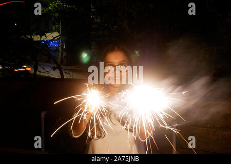 Mujer joven reventar petardos durante el Diwali en Mumbai Foto de stock