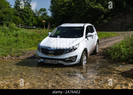  Kia Sportage  .  Crdi AWD o 4x4, color blanco, cruza el arroyo ( arroyos ), con un enfoque muy empinadas y resbaladizas rocas debajo. Coche todoterreno en el agua Fotografía de stock