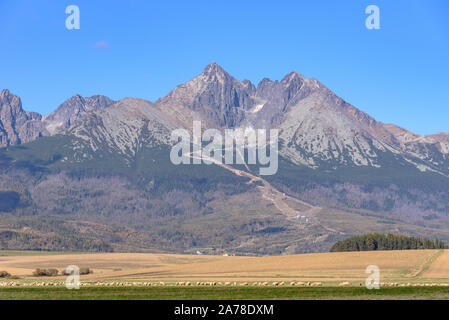 El pico Lomnicky en las Montañas Tatra Alto oriental visto desde un campo Foto de stock