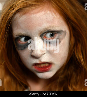 Vertical - blanco joven chica inglesa listo para la fiesta de Halloween con pintura facial y maquillaje con apariencia exagerada.