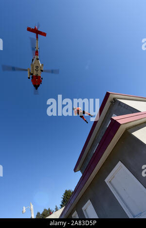 3ª clase suboficiales Bryan Evans, un técnico de supervivencia de la aviación en el sector de la Guardia Costera Río Columbia, se ha bajado de un MH-60 Jayhawk helicóptero hasta el tejado de un edificio de apartamentos simulado en el Camp Rilea las operaciones militares en el territorio urbano Village en Warrenton, Oregon, el 1 de noviembre de 2019. Esta capacitación fue diseñada para dar a los equipos de rescate y búsqueda de la experiencia necesaria para realizar operaciones de transporte aéreo urbano. (Ee.Uu. Foto por la guardia costera de 3ª clase Suboficiales Trevor Lilburn)