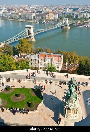 Los turistas en la terraza del Palacio Real y de la vista del río Danubio y al Puente de las cadenas. Distrito del Castillo de Buda, Buda, Budapest