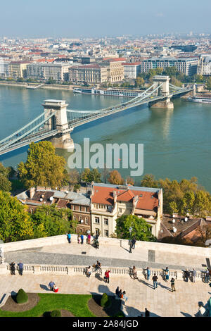 Los turistas en la terraza del Palacio Real y de la vista del río Danubio y al Puente de las cadenas. Distrito del Castillo de Buda, Buda, Budapest