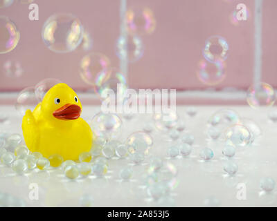 Patito amarillo en el cuarto de baño con burbujas y azulejos rosa