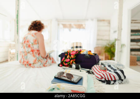 Mujer desembalaje maleta en casa de playa dormitorio Foto de stock