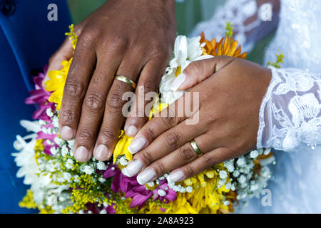 Mano Blanca y mano negra united - Novios manos unidas mediante anillos de  boda - anillos de boda de oro Fotografía de stock - Alamy