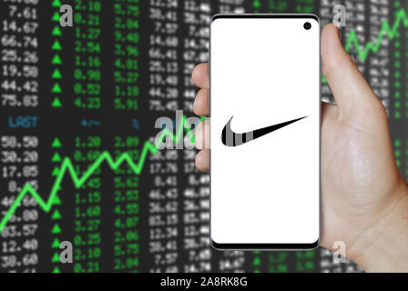 Logotipo de empresa pública Nike aparece en smartphone. Fondo negativo los de valores. Crédito: PIXDUCE de stock - Alamy