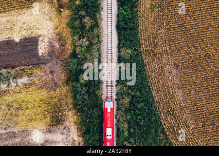 Vista aérea del tren de pasajeros por ferrocarril a través de otoño paisaje paisaje, vista superior de drone POV