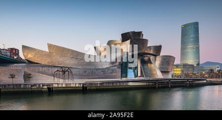 Ver al amanecer en el río Nervión hacia el Museo Guggenheim. En el fondo, Torre Iberdrola Bilbao, España