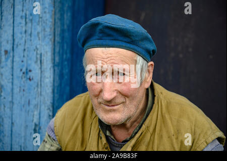 Retrato de hombre anciano en boina en el porche de una casa de pueblo Fotografía stock - Alamy