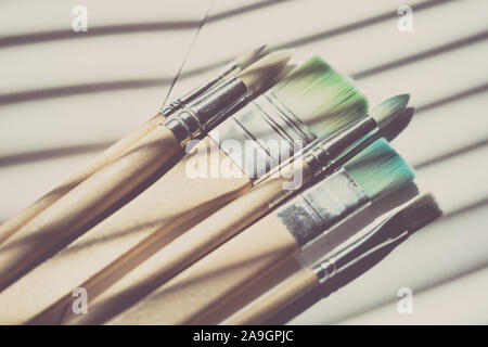 Conjunto de usa diferentes pinceles para pintar sobre la mesa. Foto de stock