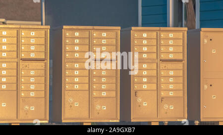 Panorama de los buzones de correo con los números de fila y compartimentos junto a una carretera en un día soleado Foto de stock