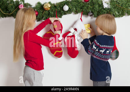 Adorable pequeño los niños abren sus regalos en la mañana de Navidad stock Foto de stock
